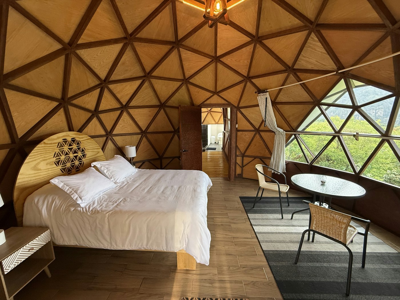 Interior del Domo Orión con terraza, ventanal geométrico y vista a la montaña